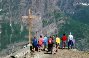 Un groupe de gens avec une croix devant des montagnes